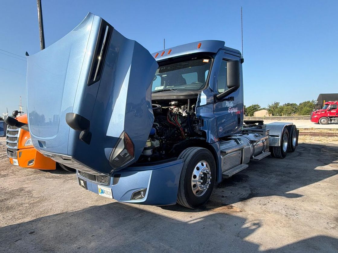Diesel diagnostics on a day cab tractor with the hood open at a DFW terminal
